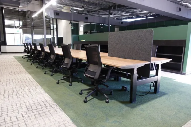 A large boardroom table with black commercial chairs